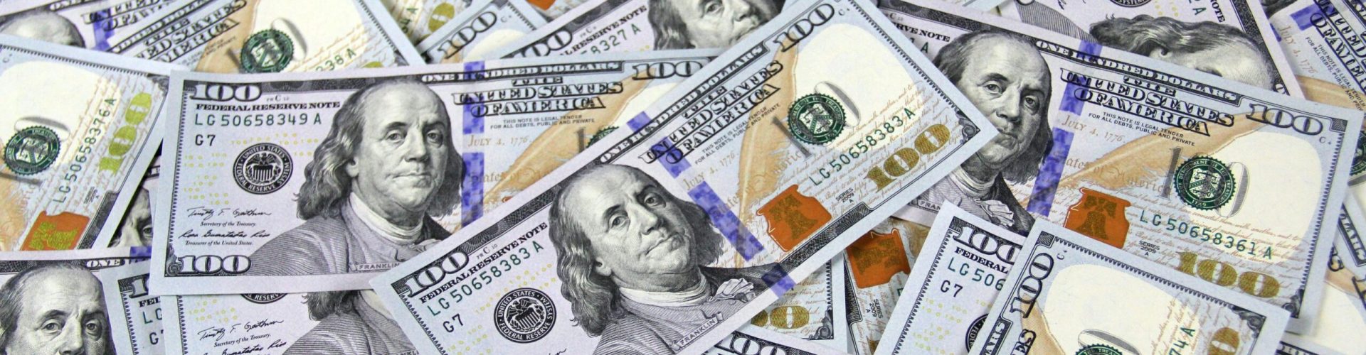 Pile of US hundred dollar bills depicting financial success and wealth.